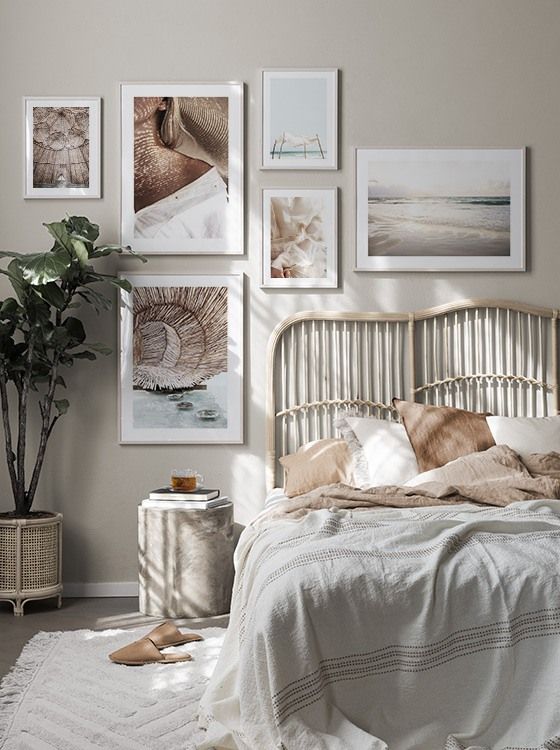 Woven-look curved headboard beneath white-framed artwork, with sand-colored pillows and a gray striped bed cover.