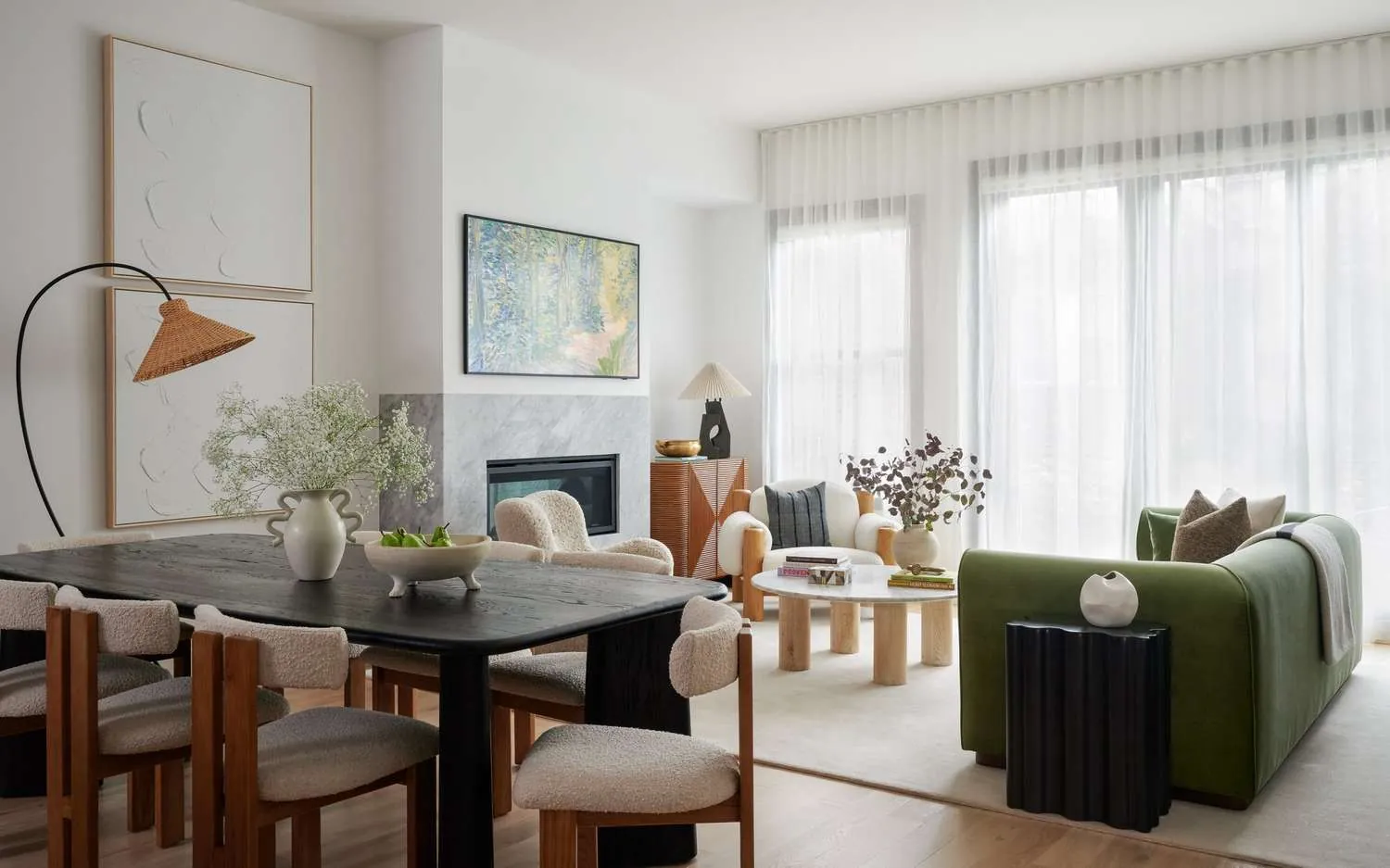White sheer curtains span a wide living room window behind a green sofa.
