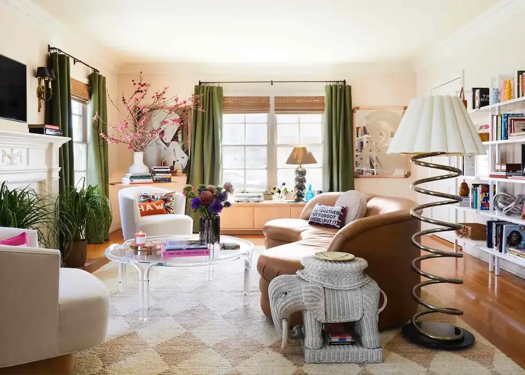 A tall floor lamp beside a tan armchair and white bookshelves.