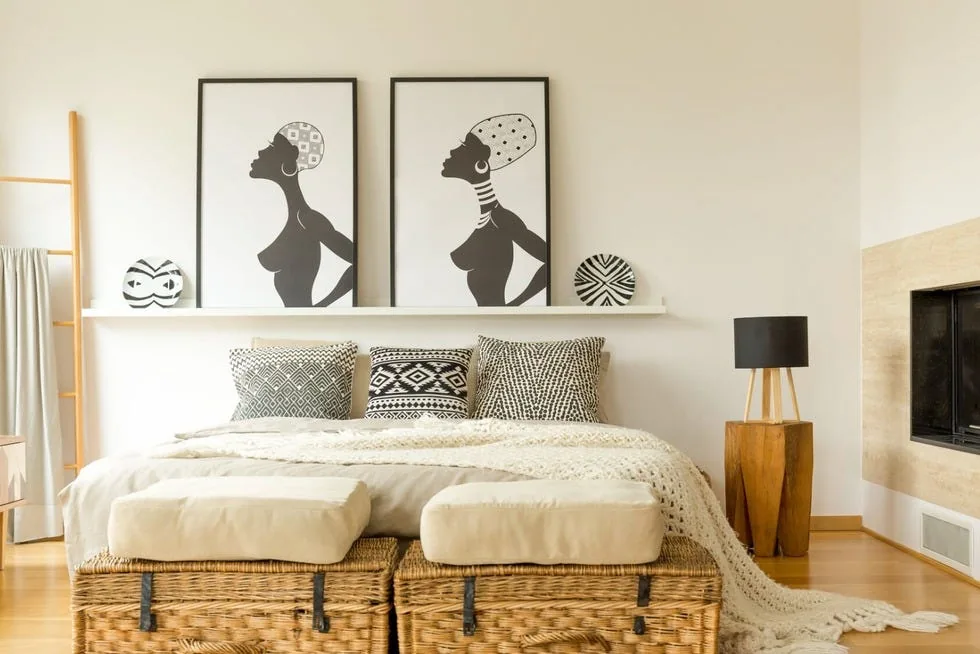 Two woven storage trunks sit at the foot of a bed beneath pale cushions.